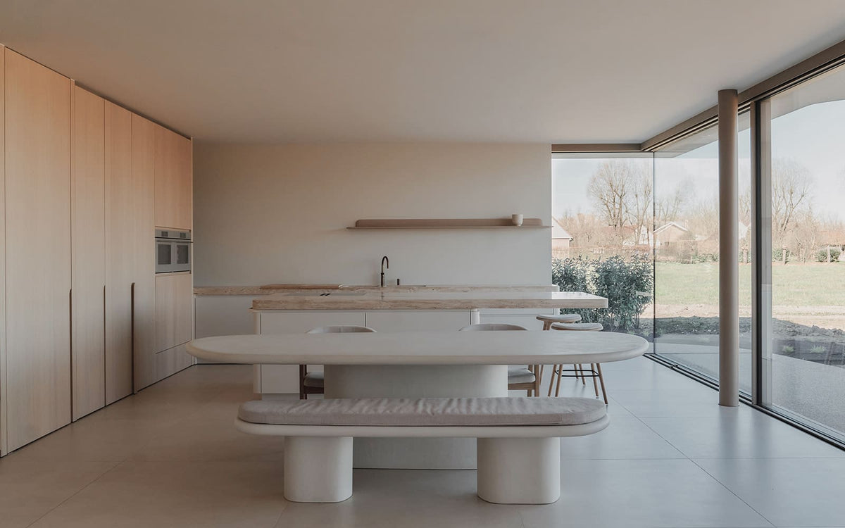 Witte mortex tafel met bijhorende mortex bank die dient als zitplaats in de keuken