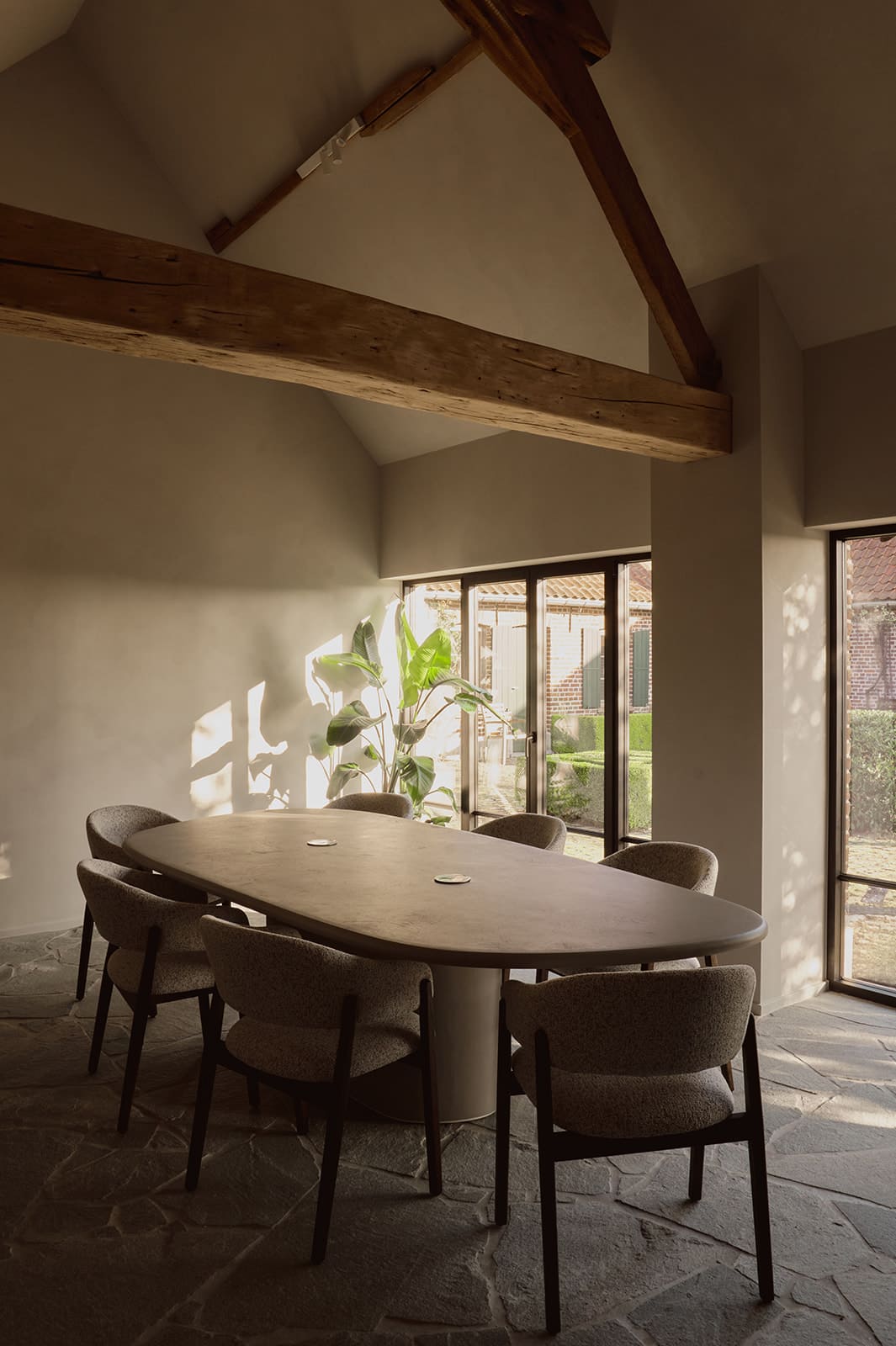 Een mortex tafel die in hoogte kan versteld worden in een landelijk interieur met stopcontacten in de tafel zelf